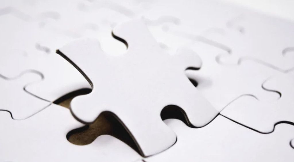Scattered white jigsaw puzzle pieces