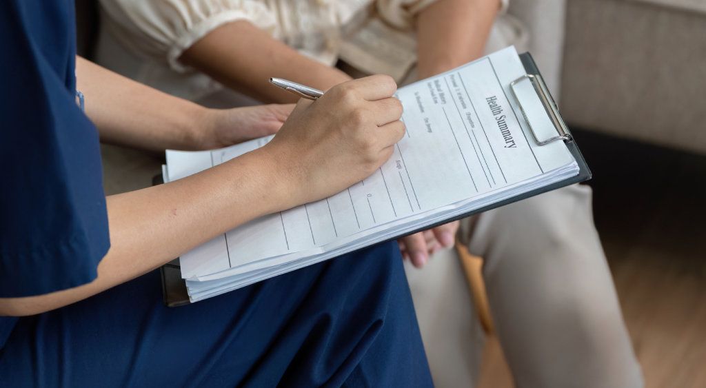 A person filling in a form on a clipboard